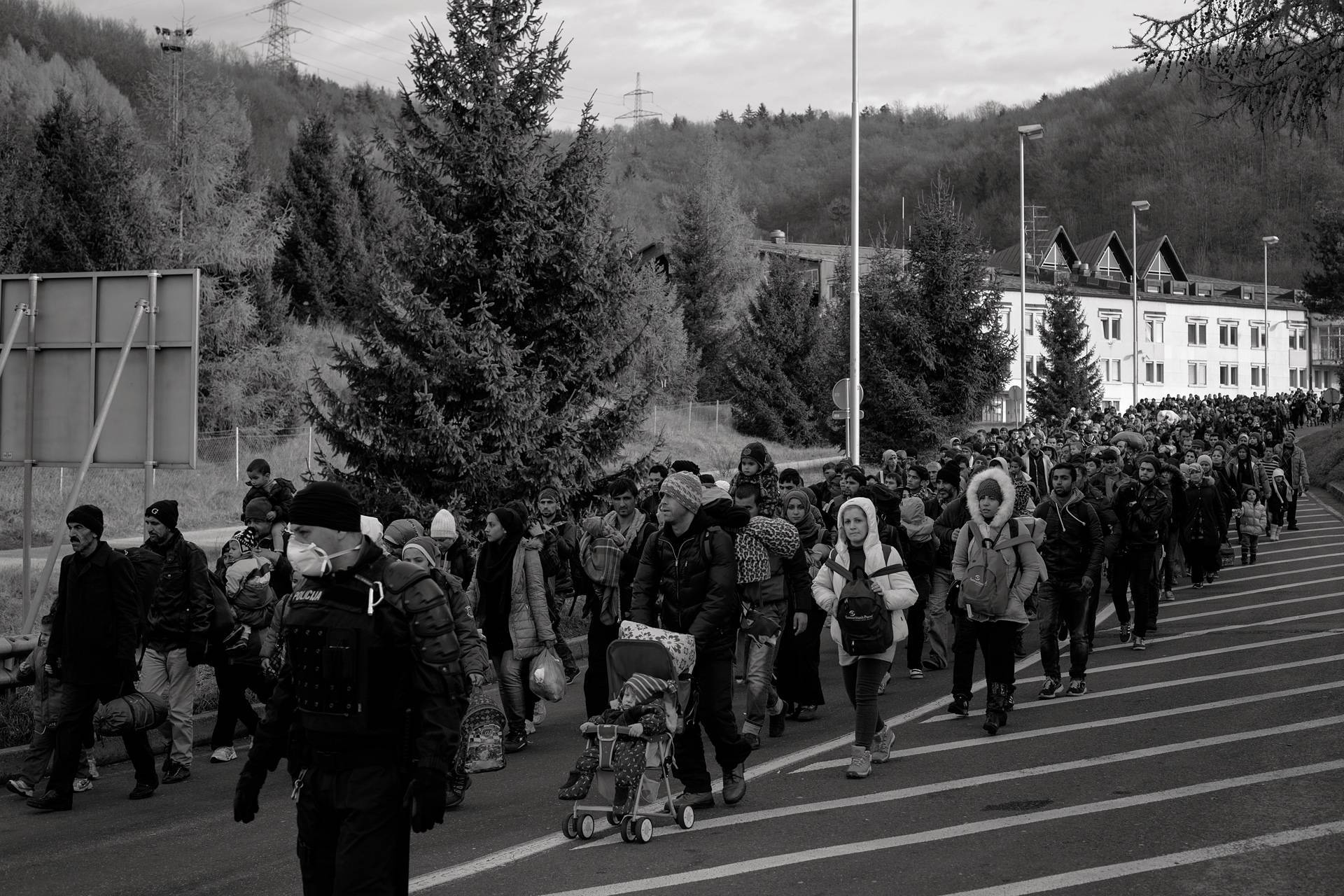 20. November 2015. Šentilj, Slowenien. Slowenische Polizeikräfte und Militär begleiten eine Gruppe Geflüchtete zum Grenzübergang nach österreichischem Spielfeld.