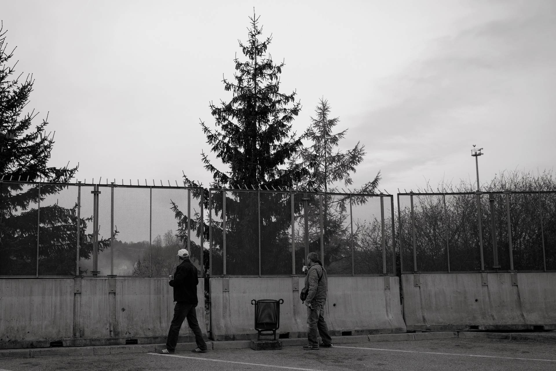 20. November 2015. Šentilj, Slowenien. Bauarbeiter sehen auf das slowenische „Niemandsland“ hinunter, während sie es mit massiven Zäunen von einem Autobahnparkplatz absichern.